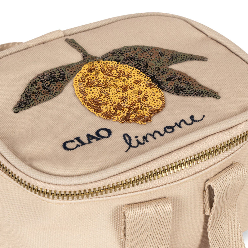 Lille beige termotaske med citronmønster på toppen.