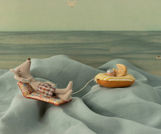 Far mus med badebukser om luftmadras med blomstermønster.