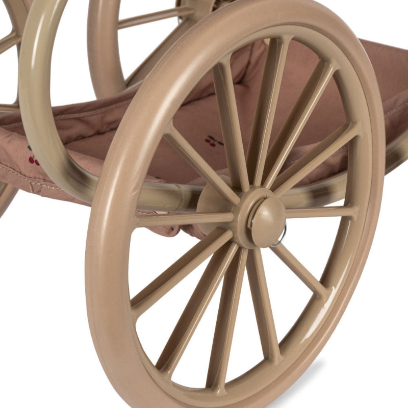 Vintage dukkevogn med rosa stof og kirsebærprint.