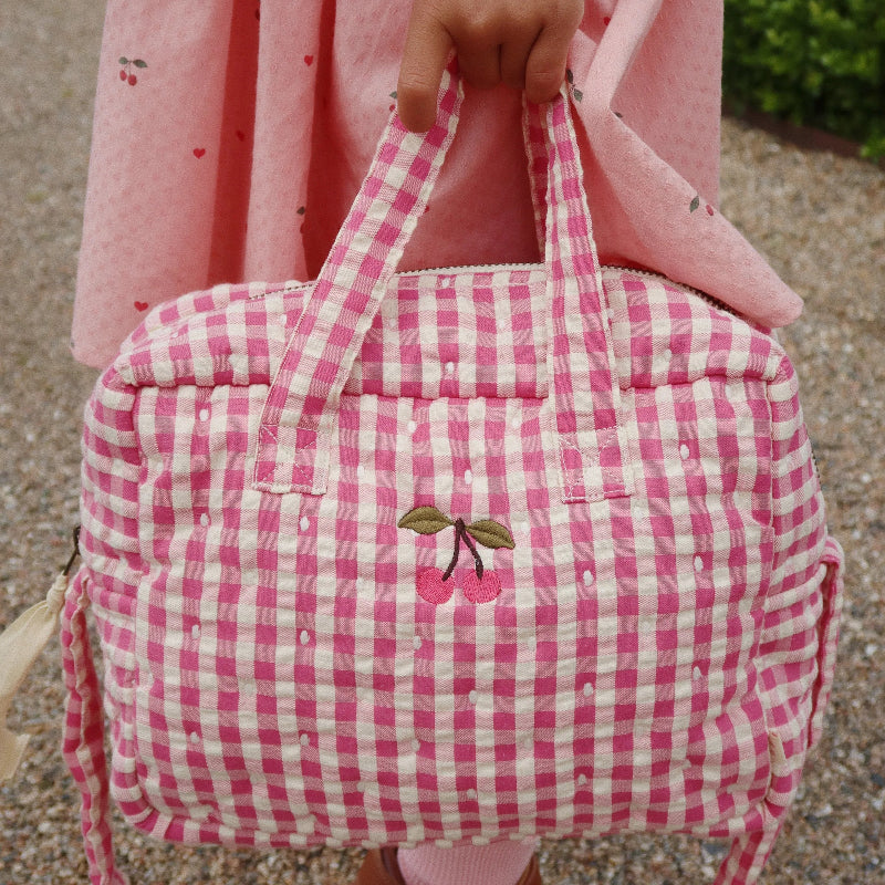 Pusletaske til dukker i pink ternet mønster.