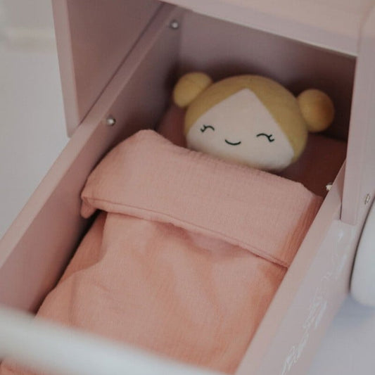 Lyserødt dukkesengetøj.