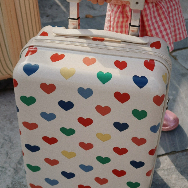 Beige kuffert med hjerte print i flere farver.