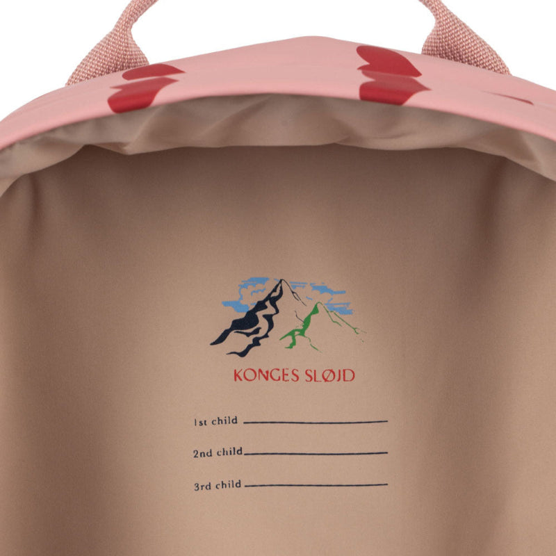 Lyserød rygsæk med røde hjerter.