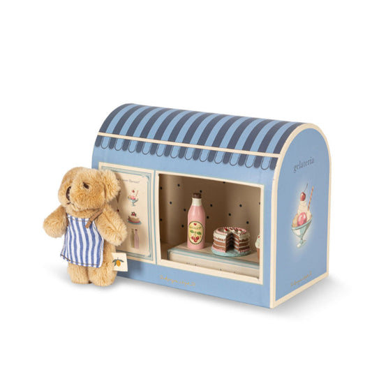 Lille kagebutik og bamse med forklæde.