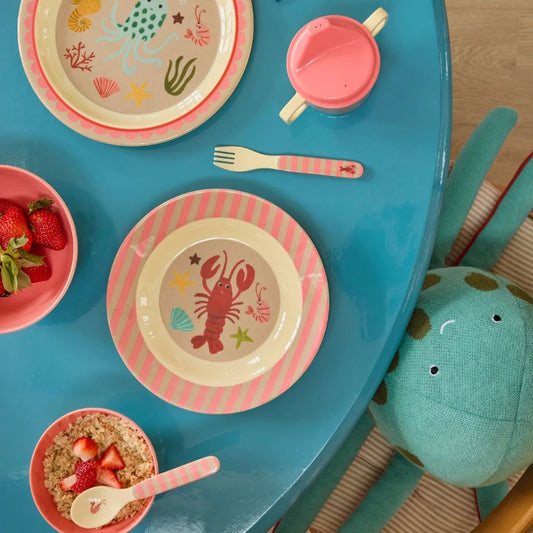 Lyserød ske og gaffel.