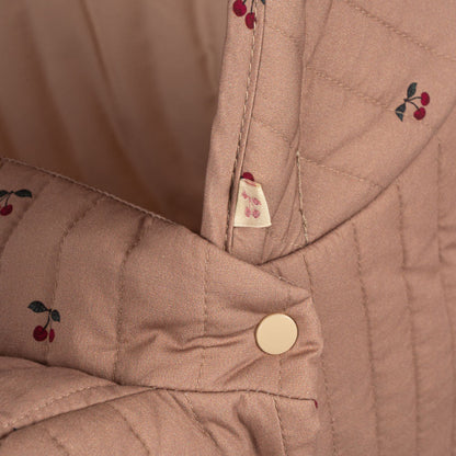 Vintage dukkevogn med rosa stof og kirsebærprint.