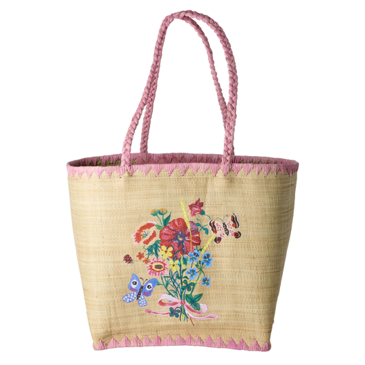 Taske i naturmaterialet raffia. Tasken har en lyserød kant og hank. På midten er der smukke blomster af lyserød, blå, rød og gul med smukke sommerfugle omkring.