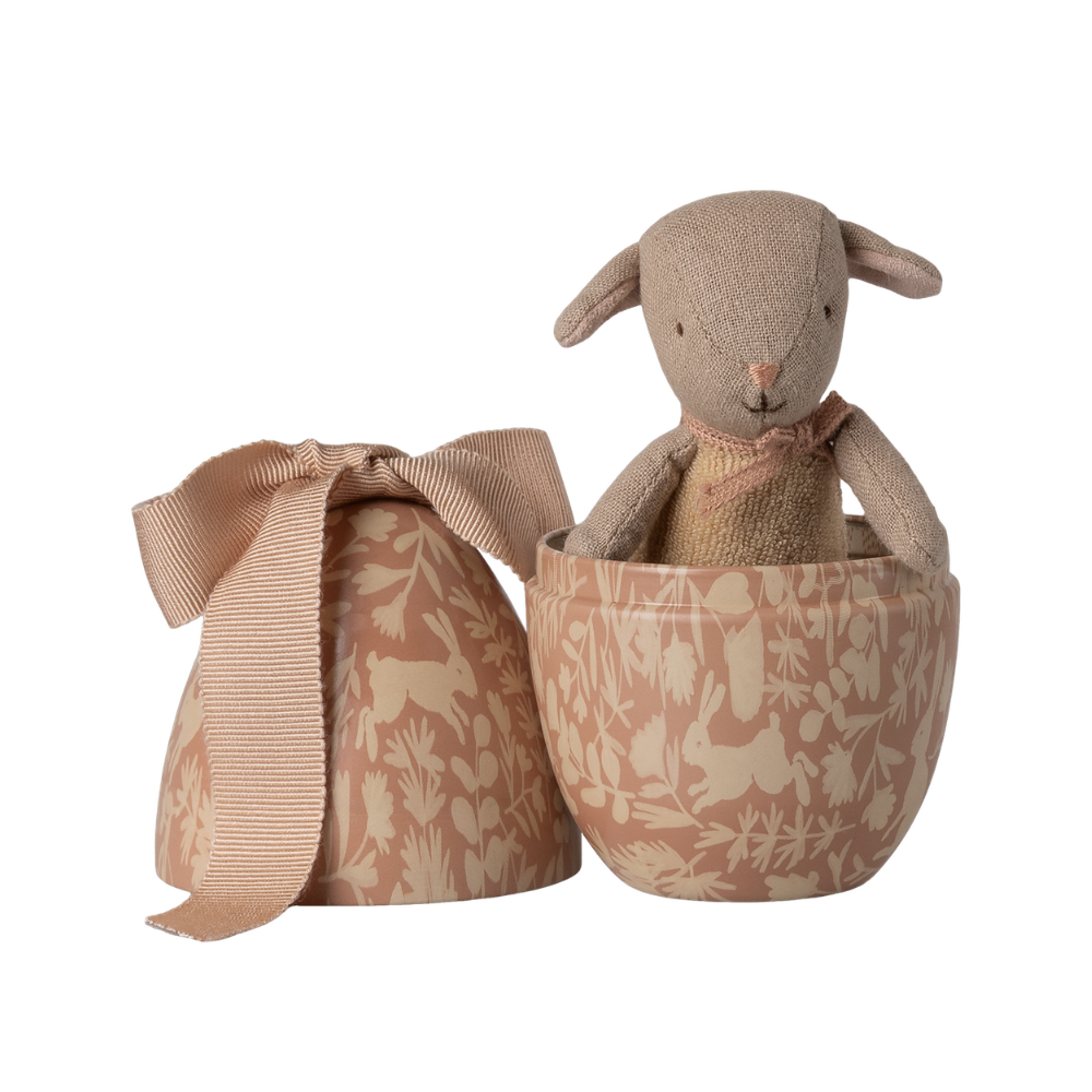 Lyserødt metal påskeæg med en lille lam bamse indeni.