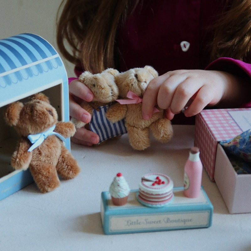 Lille brun bamse i blå æske med pude og dyne.